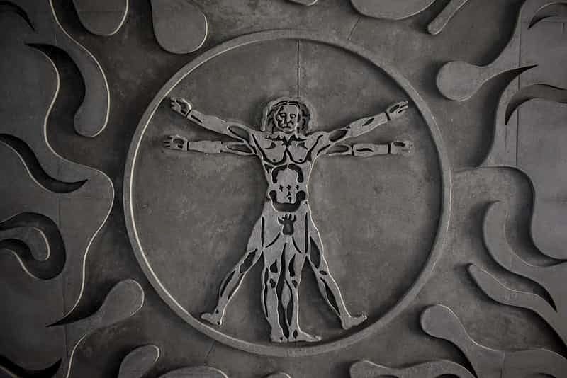 a close-up of a coin depicting an interpretation of Leonardo da Vinci's Vitruvian Man