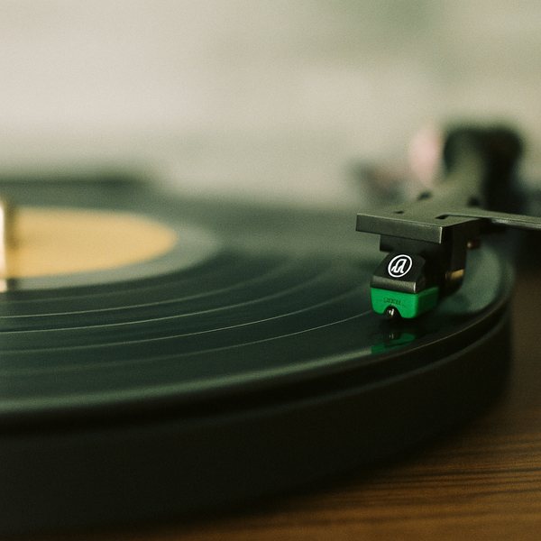 black vinyl record player on brown wooden table