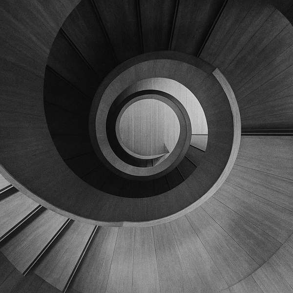 a wooden spiral staircase with a light at the end